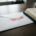 Witte envelop met rood DISPUTED-stempel op donker eiken bureau naast papieren factuur en zwarte pen.