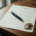 Gedrukt contract op donker eikenhouten bureau met zwarte pen en euromunten in natuurlijk licht.