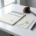 Formele factuur op wit bureau naast een houten hamer, verzegelde envelop en vulpen, in zakelijke juridische sfeer.