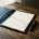 Opengevouwen leren contractmap op donker eiken bureau met ongetekende pagina en fonteinpen, zacht natuurlijk raamlicht.