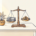 Houten weegschaal met facturen en munten op bureau, potplant ernaast, in marineblauw en amber tinten.